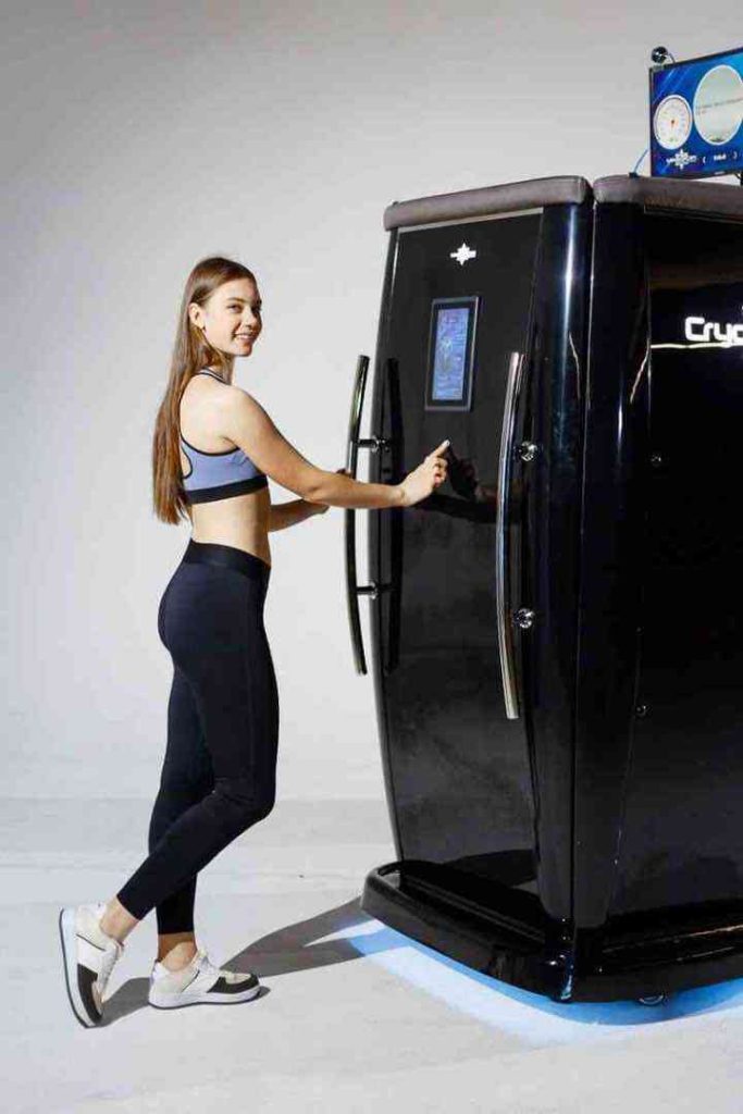 Donna che apre la camera crioterapica CryoStar