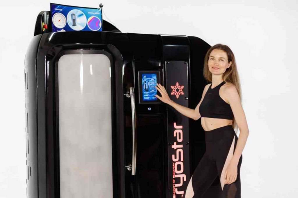 Donna che imposta la camera crioterapica CryoStar dal touchscreen