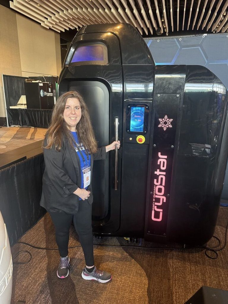 Donna accanto alla camera CryoStar nera in fiera