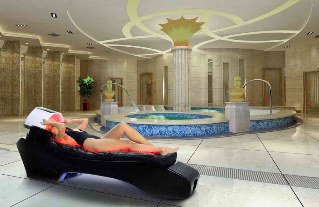 Donna sdraiata sull'InfraCouch in una spa con piscina